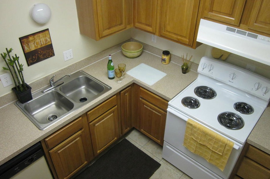 The kitchen in this one-bedroom rental has a dishwasher, double stainless steel sink, and a clean stove. 