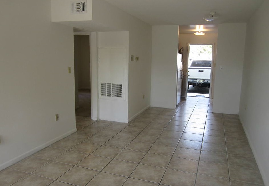 There are tile floors in the empty living room and kitchen of the two-bedroom rental. 