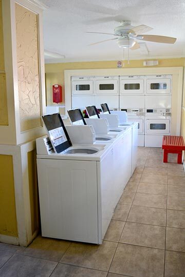 The laundry room is lined with washing and drying machines.
