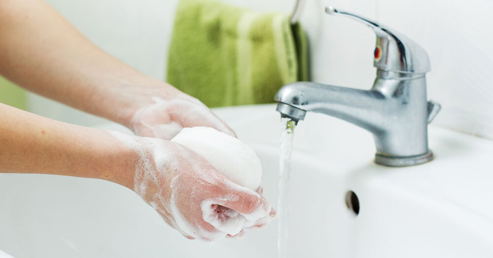 An individual washing their hands with soap and water.