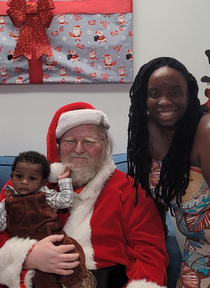 A woman and a baby with Santa.