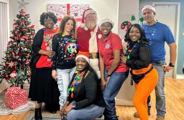 A group of people surrounding Santa.