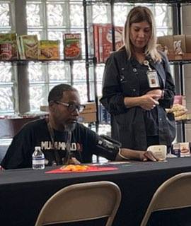 Two people at a table, one taking the others blood pressure.