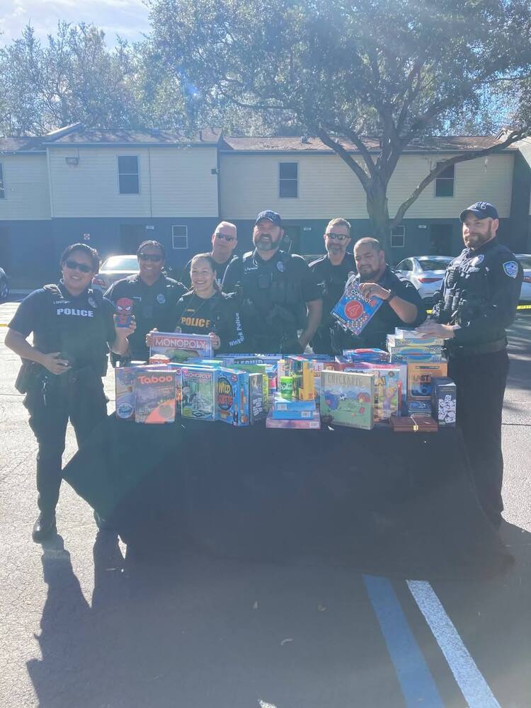 Officers of the WInter Park Police Department standing behind a table full of items.